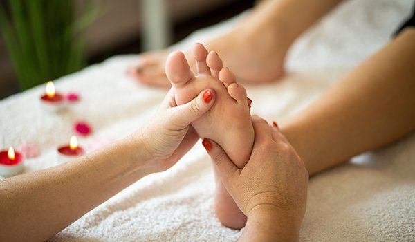 una massaggiatrice mentre massaggia il piede di una donna