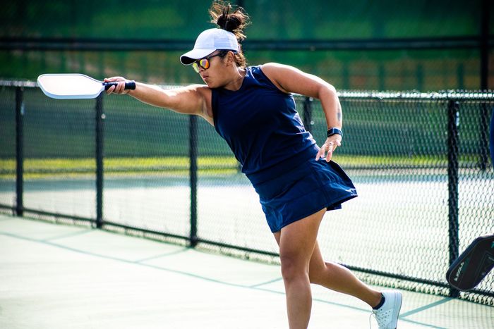 Woman in hat playing pickleball