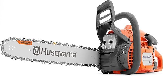 A husqvarna chainsaw is sitting on a white surface.