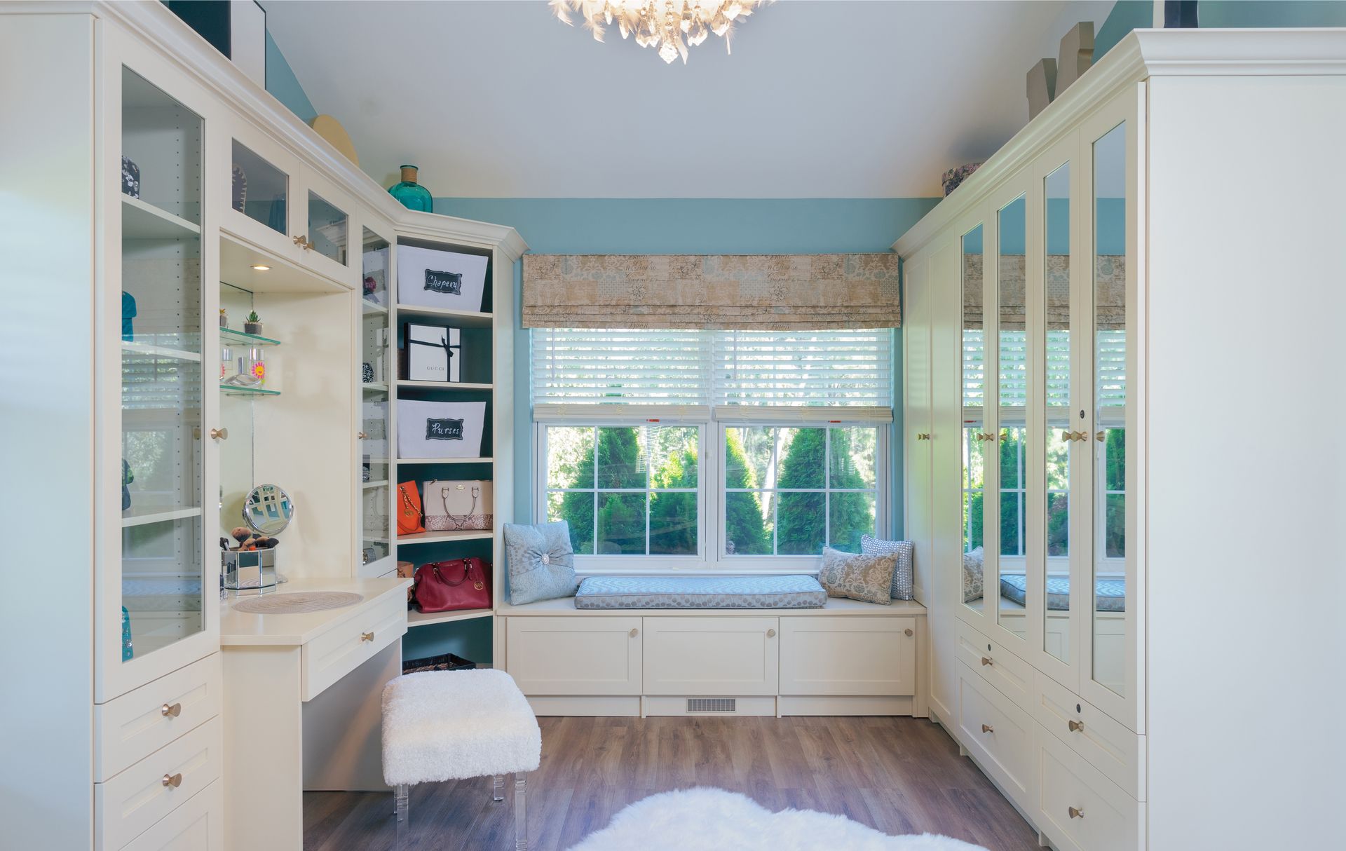White kitchen cabinets with shelves, storing food items, wine bottles, and a red mixer, next to a wood-topped island.