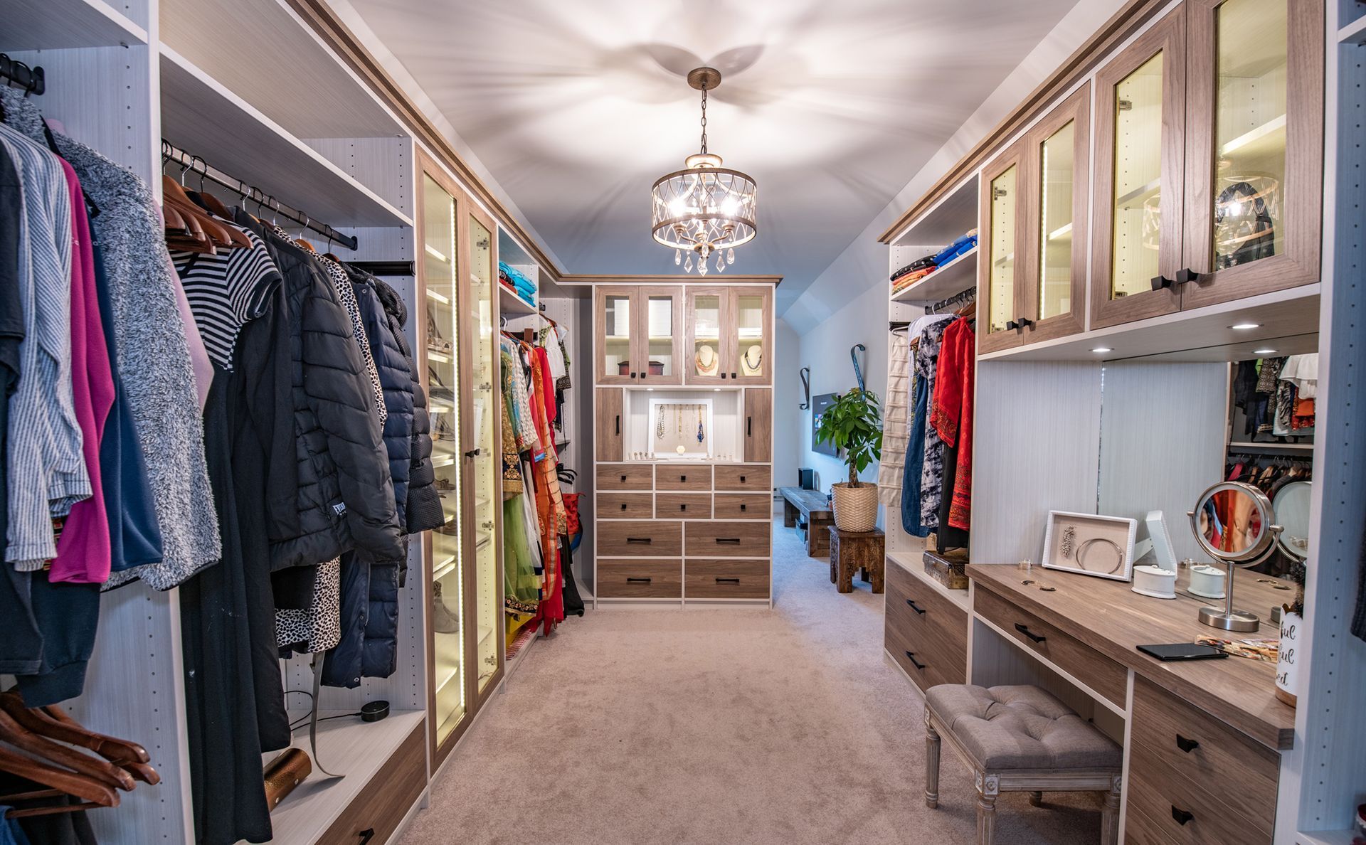 Modern laundry room with stacked washer/dryer, stainless steel cabinets, and blue accents.