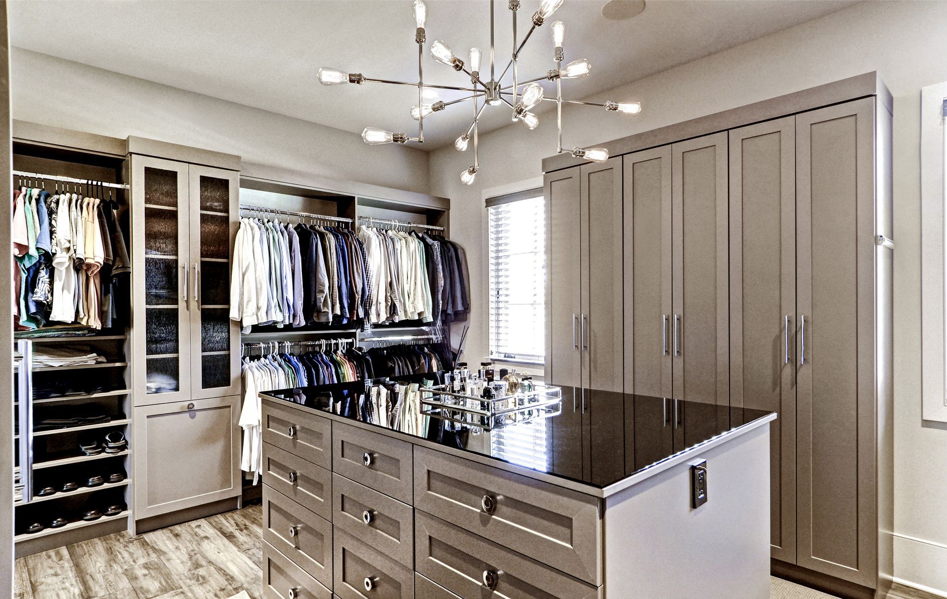 Walk-in closet with wooden shelves, clothes, luggage, and shoes.