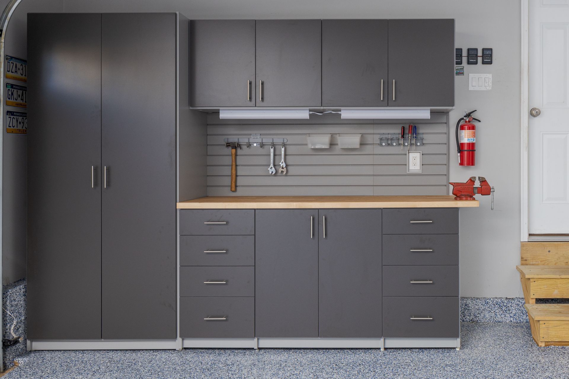 White kitchen cabinets with shelves, storing food items, wine bottles, and a red mixer, next to a wood-topped island.
