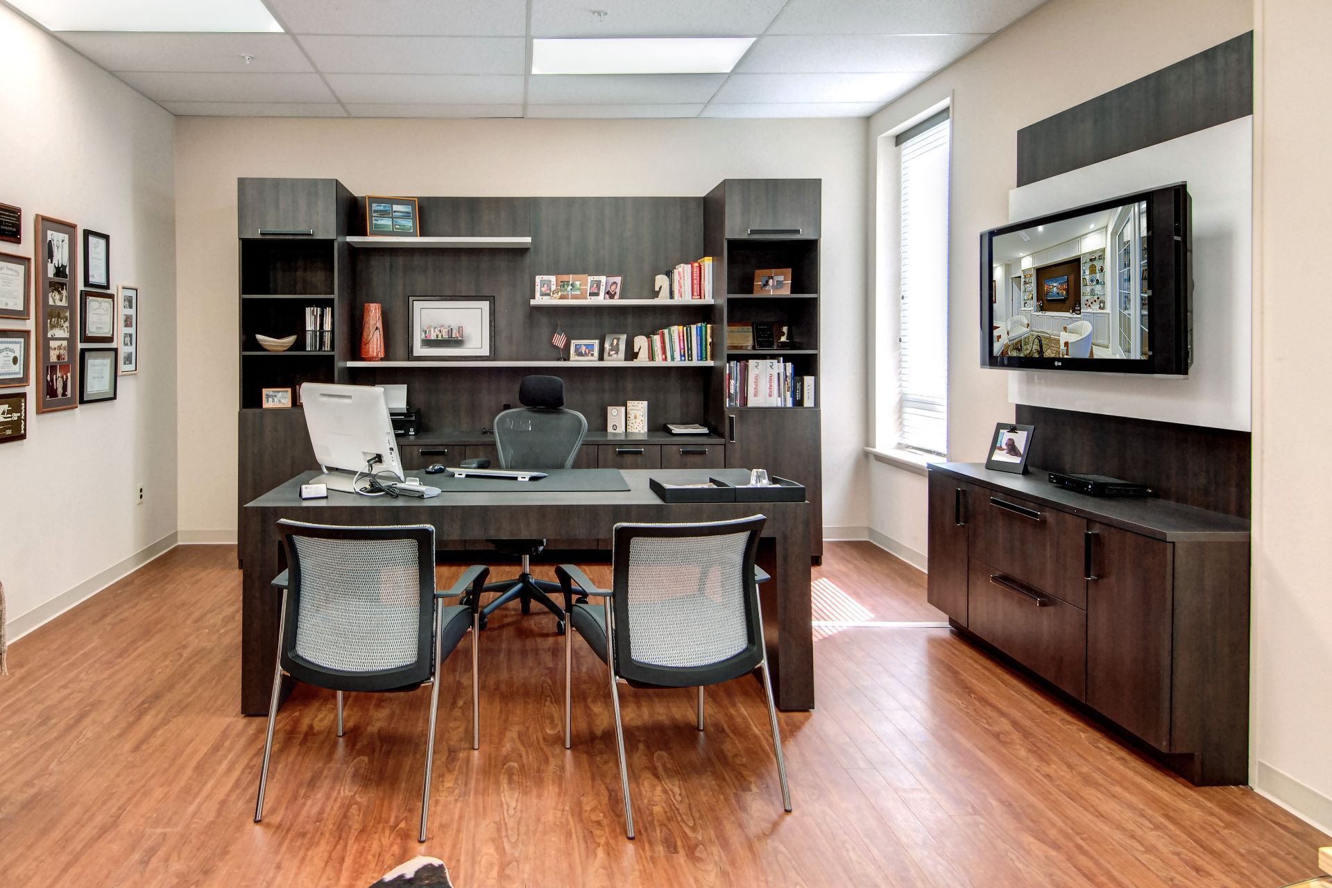 Organized white pantry shelving with various shelves, pull-out drawers, wire baskets, and hanging kitchen linens.