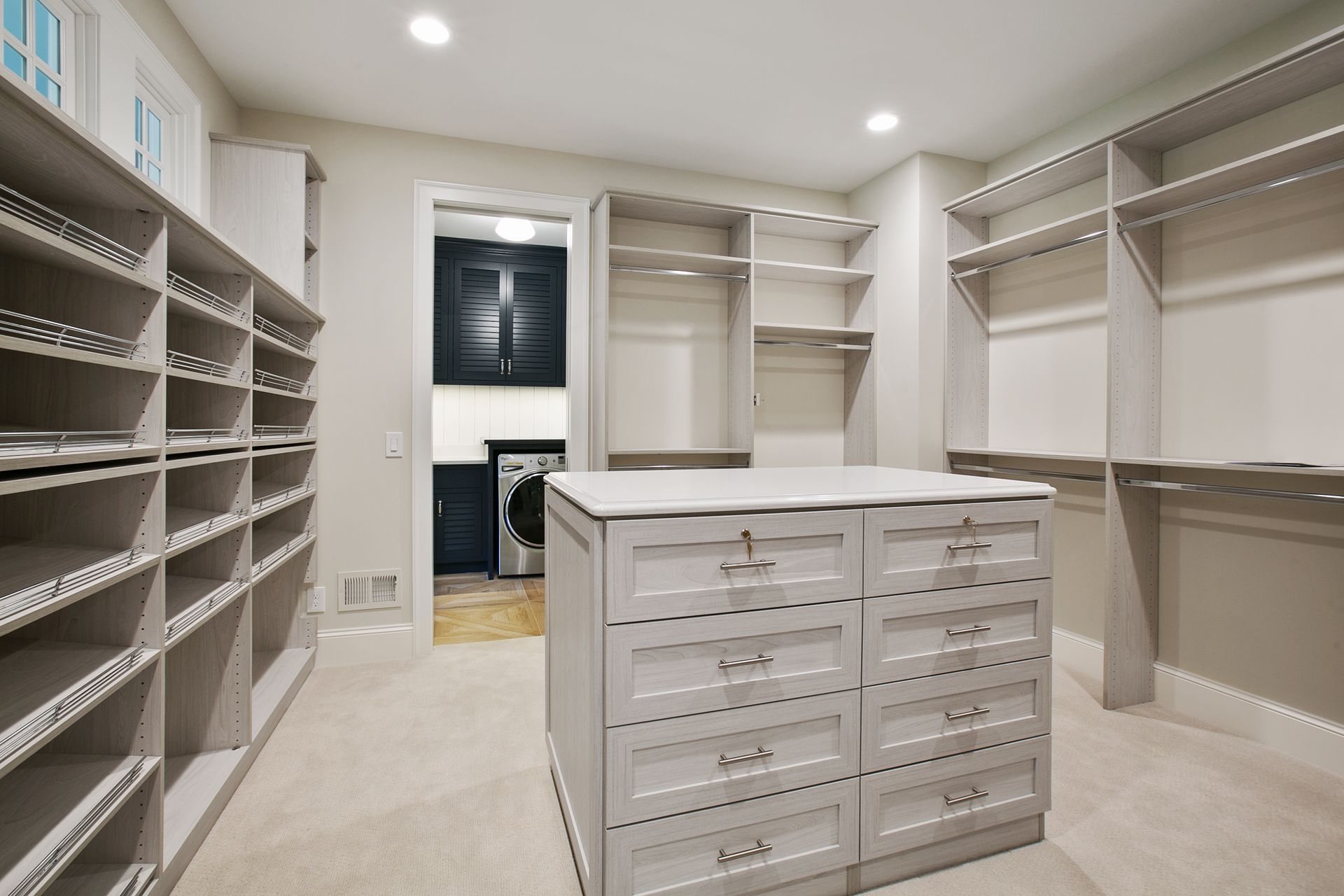 Walk-in closet with wooden shelves, clothes, luggage, and shoes.