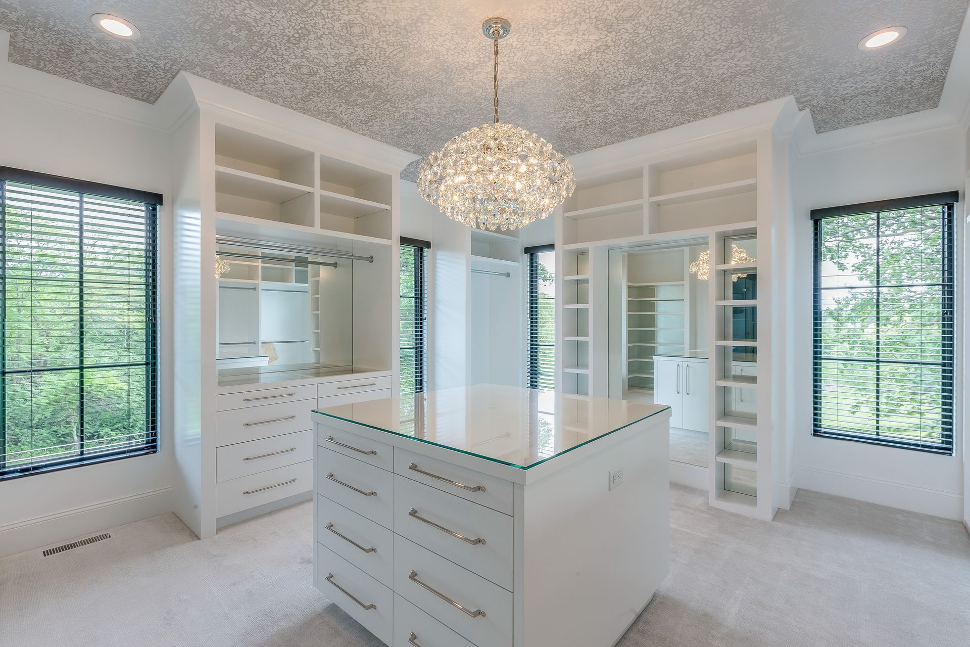 Modern laundry room with stacked washer/dryer, stainless steel cabinets, and blue accents.
