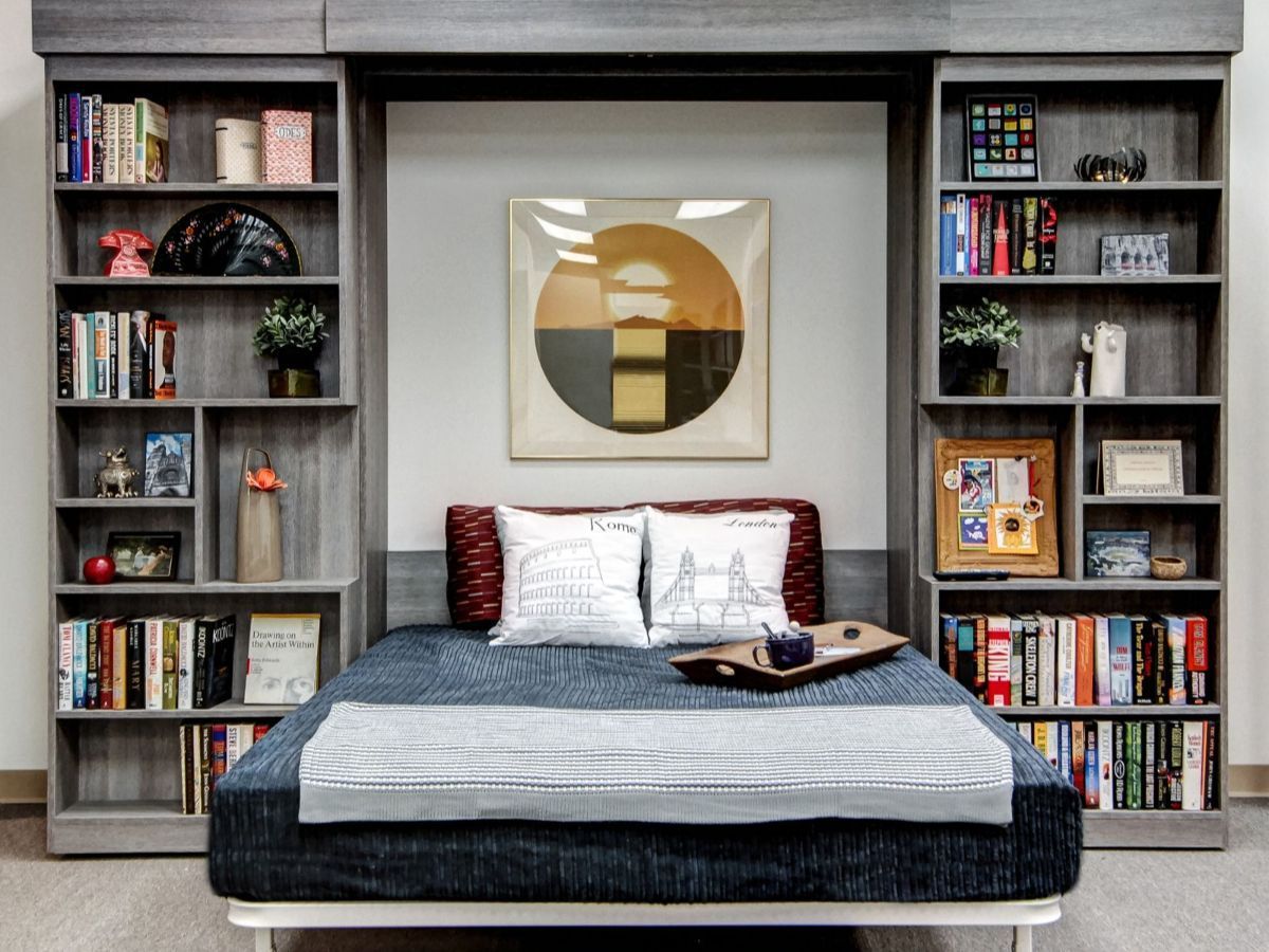 Walk-in closet with wooden shelves, clothes, luggage, and shoes.