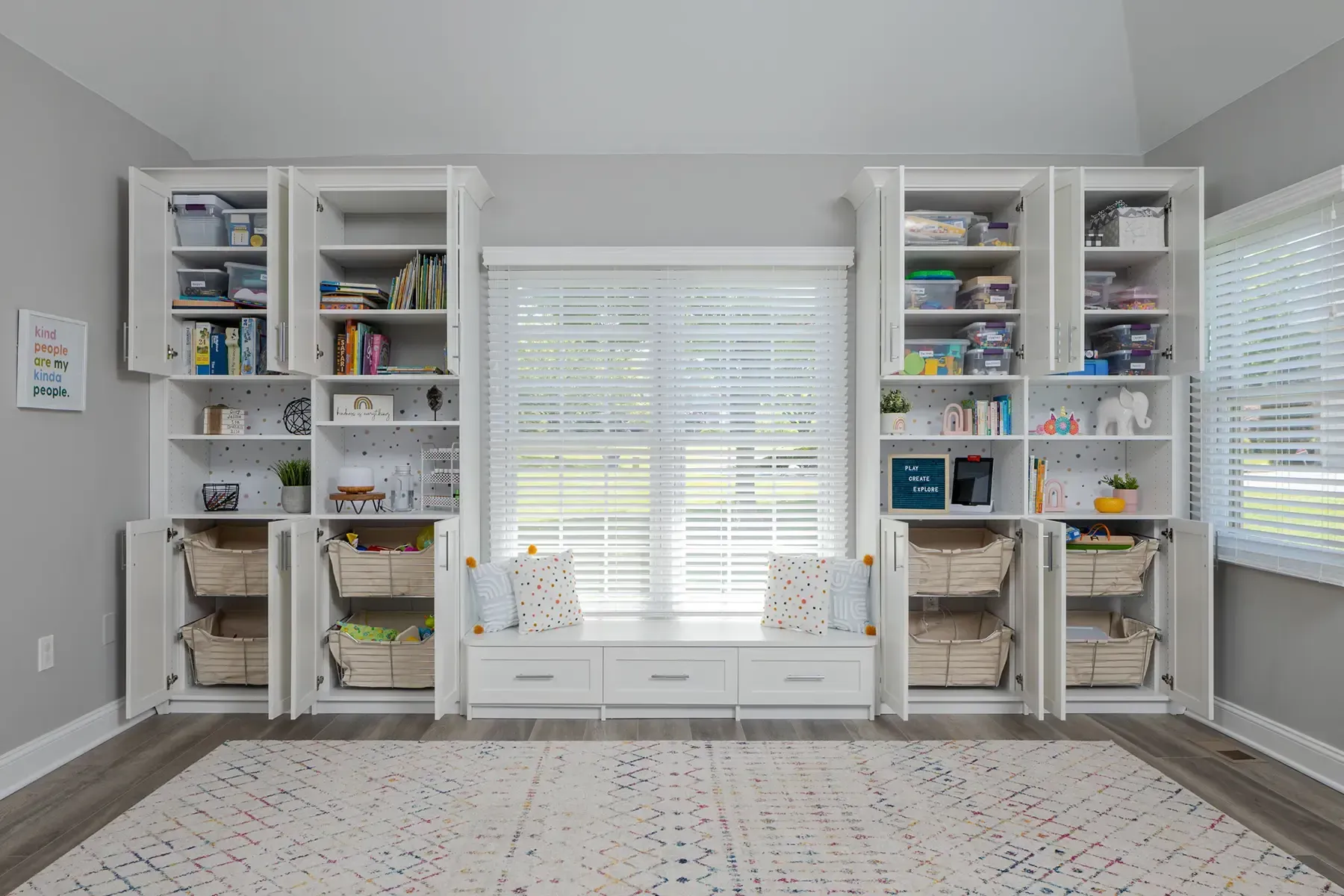 Modern laundry room with stacked washer/dryer, stainless steel cabinets, and blue accents.