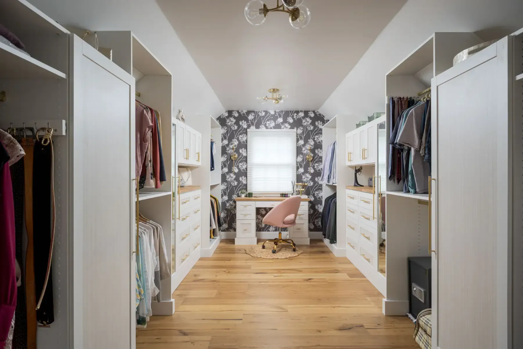 White kitchen cabinets with shelves, storing food items, wine bottles, and a red mixer, next to a wood-topped island.