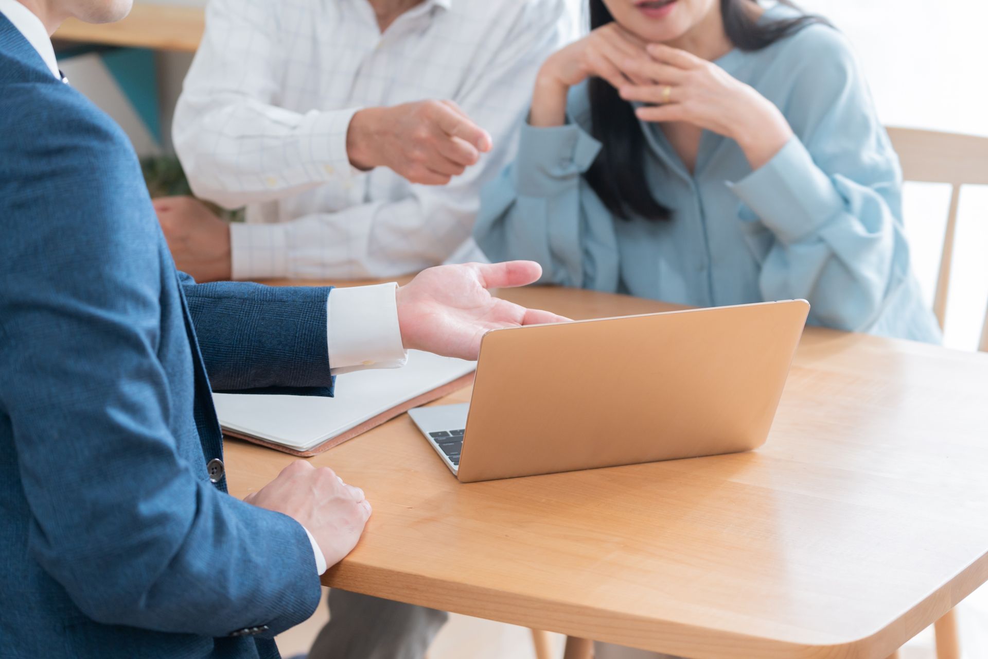 A man and a woman are sitting at a table with a laptop