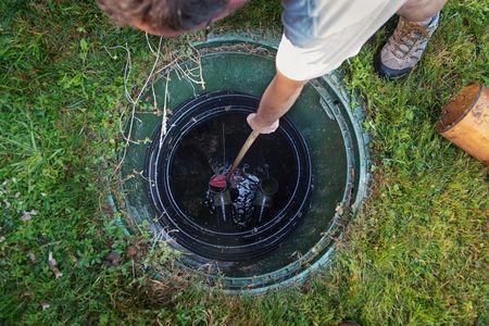 a man is using a plunger to drain a septic tank