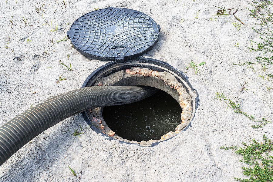 a manhole cover is open and a hose is coming out of it