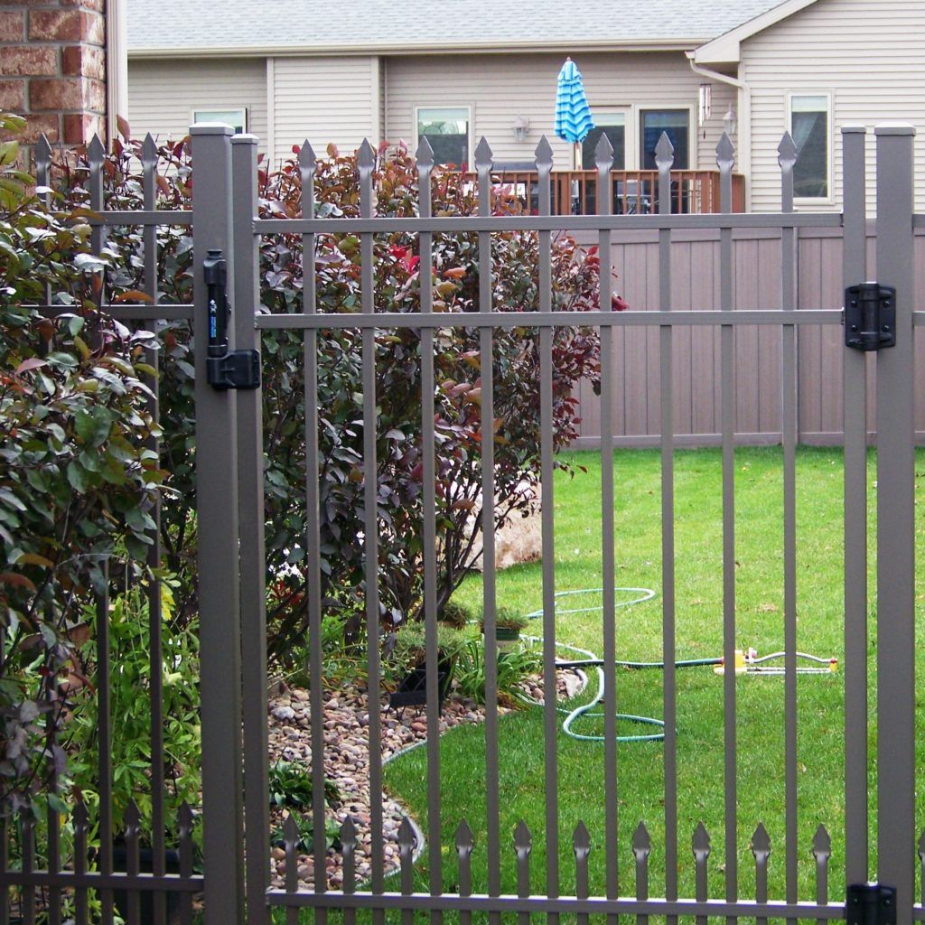 An aluminum fence surrounds a lush green yard