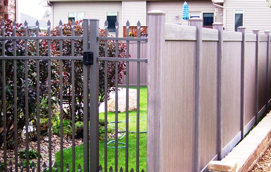 A fence with a gate in front of a house