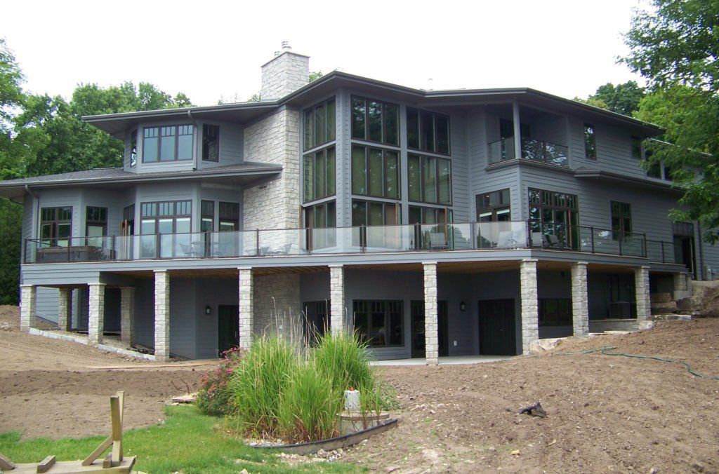 A large house with a lot of windows and a large balcony with a glass railing