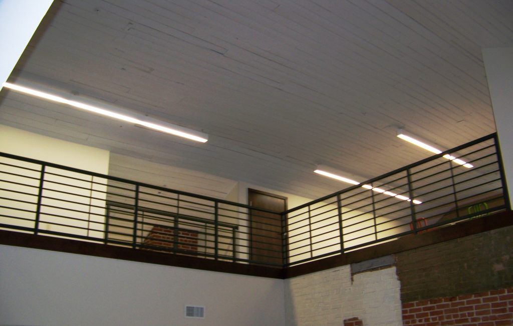 A balcony with a railing and lights on the ceiling