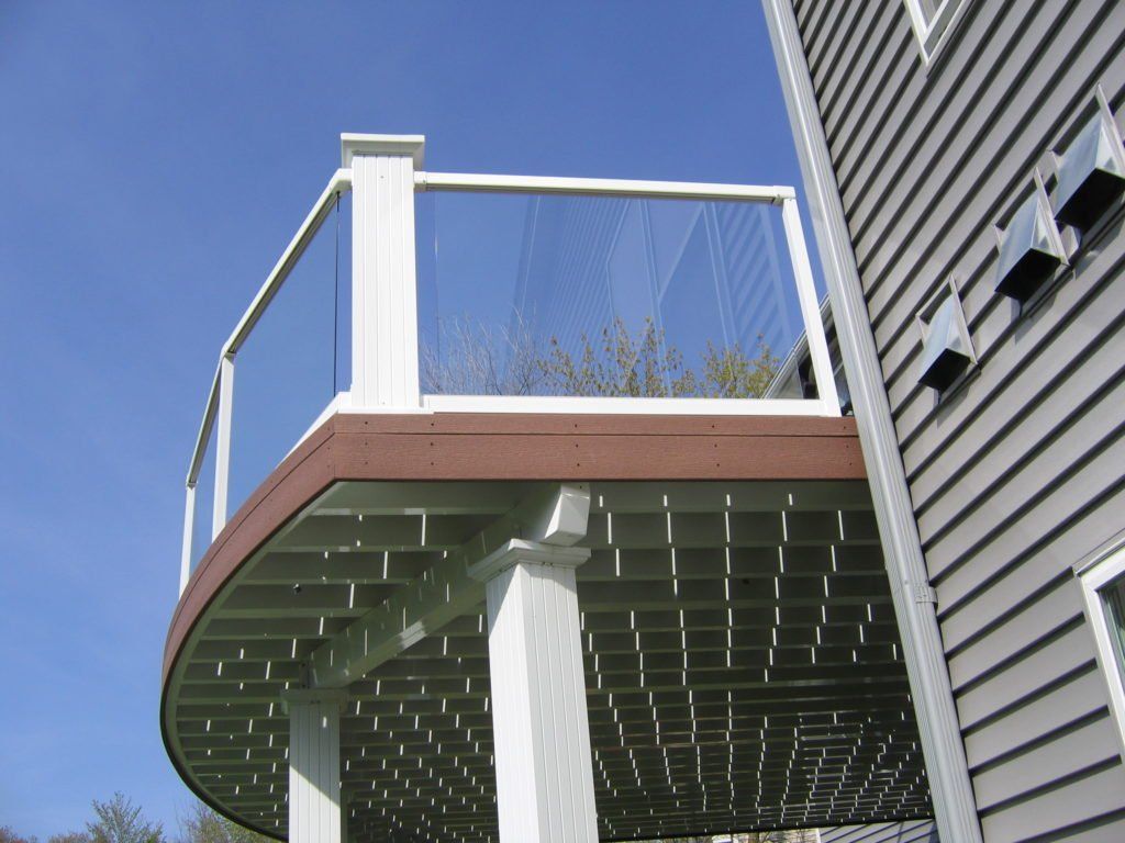 A house with a deck and glass railing panels 