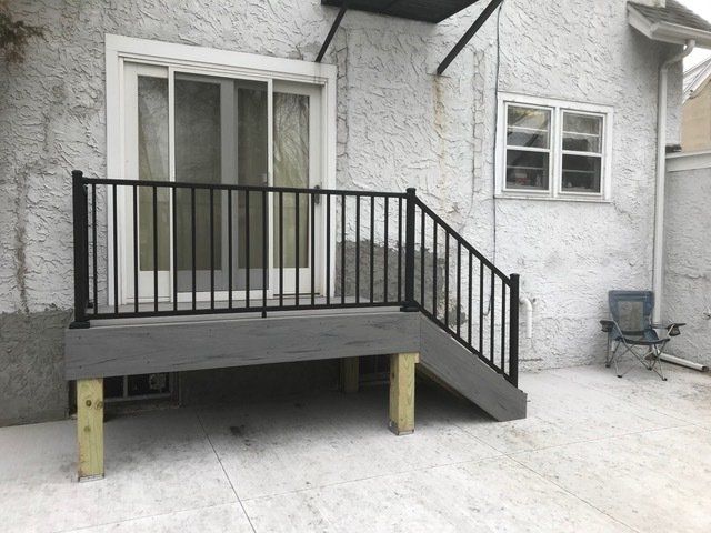 A deck with stairs leading up to a sliding glass door
