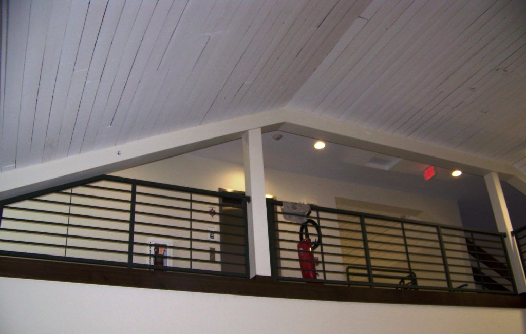 A balcony with a railing and lights on the ceiling