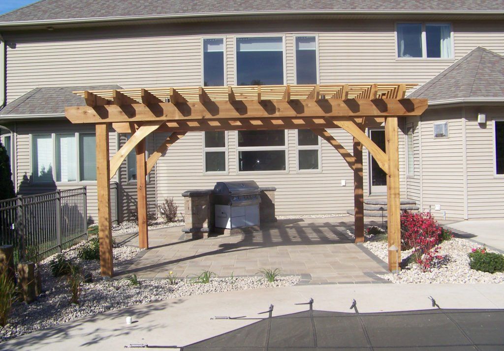 A house with a wooden pergola on a patio