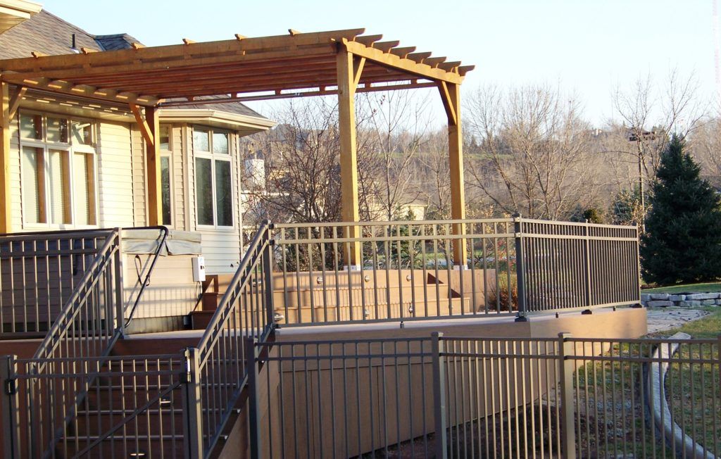 A deck with a pergola and stairs leading up to it