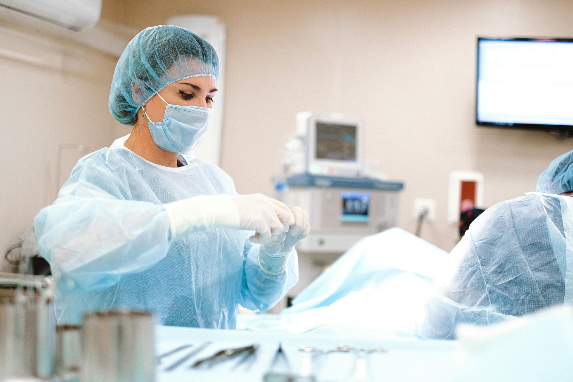 A female surgeon is preparing a patient for surgery in an operating room.