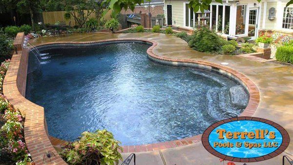 A large swimming pool is in the backyard of a house.