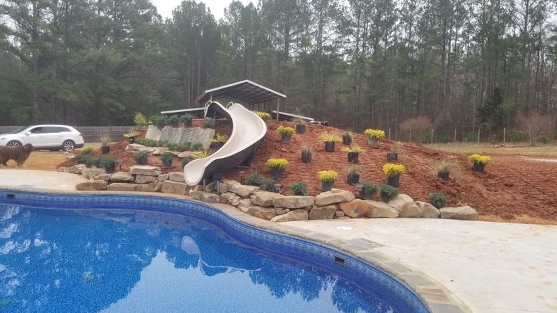 A swimming pool with a slide and a car parked next to it.