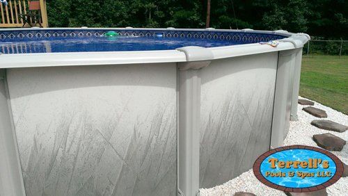 A large swimming pool is sitting in the middle of a lush green field.