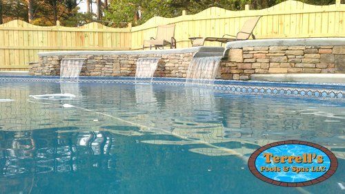 A large swimming pool with a waterfall in the middle