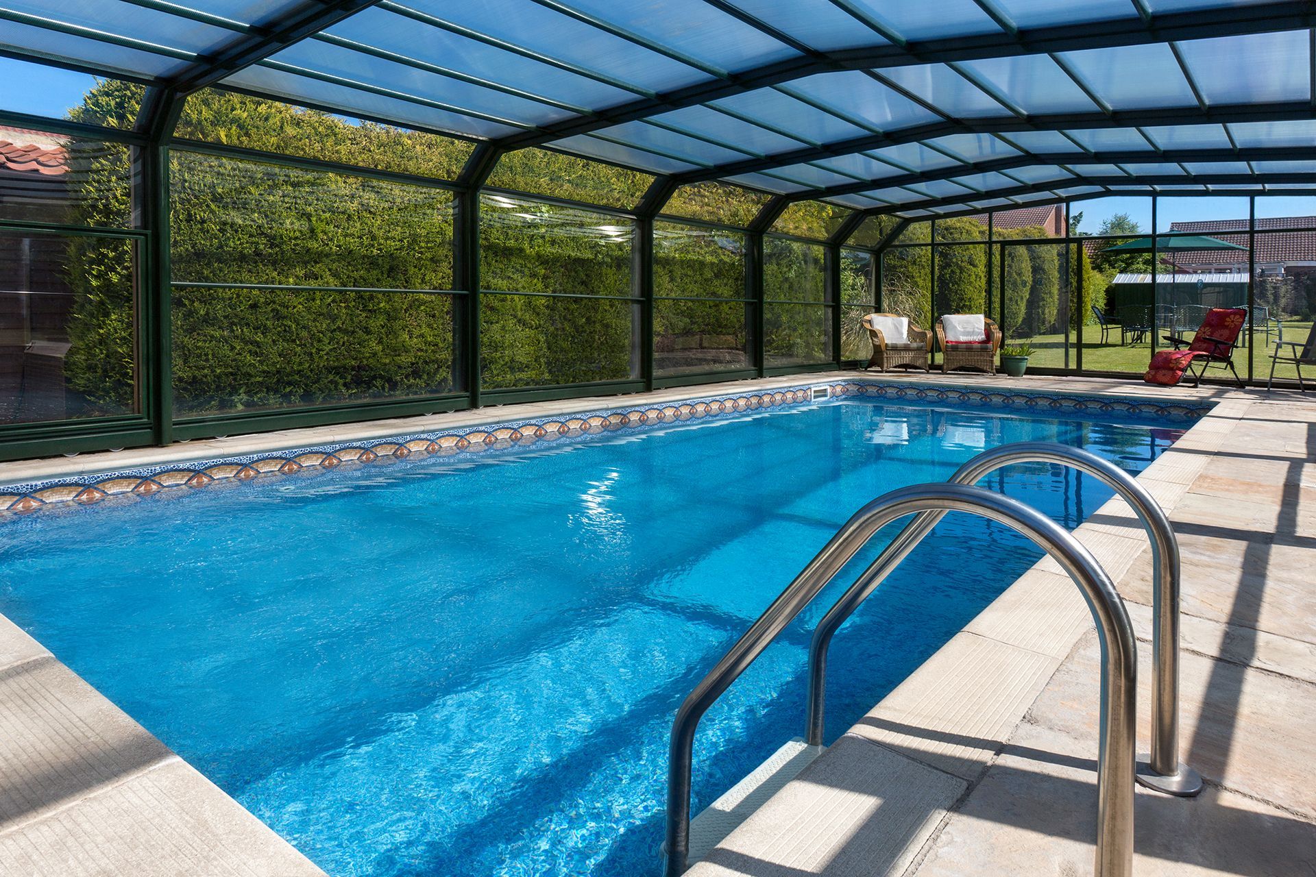 A large indoor swimming pool with a clear roof