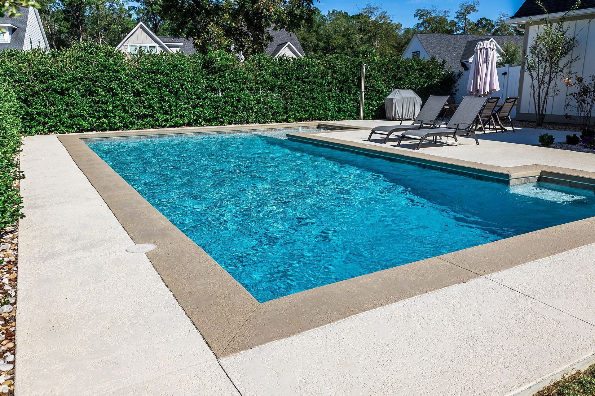 A large swimming pool with chairs and umbrellas around it