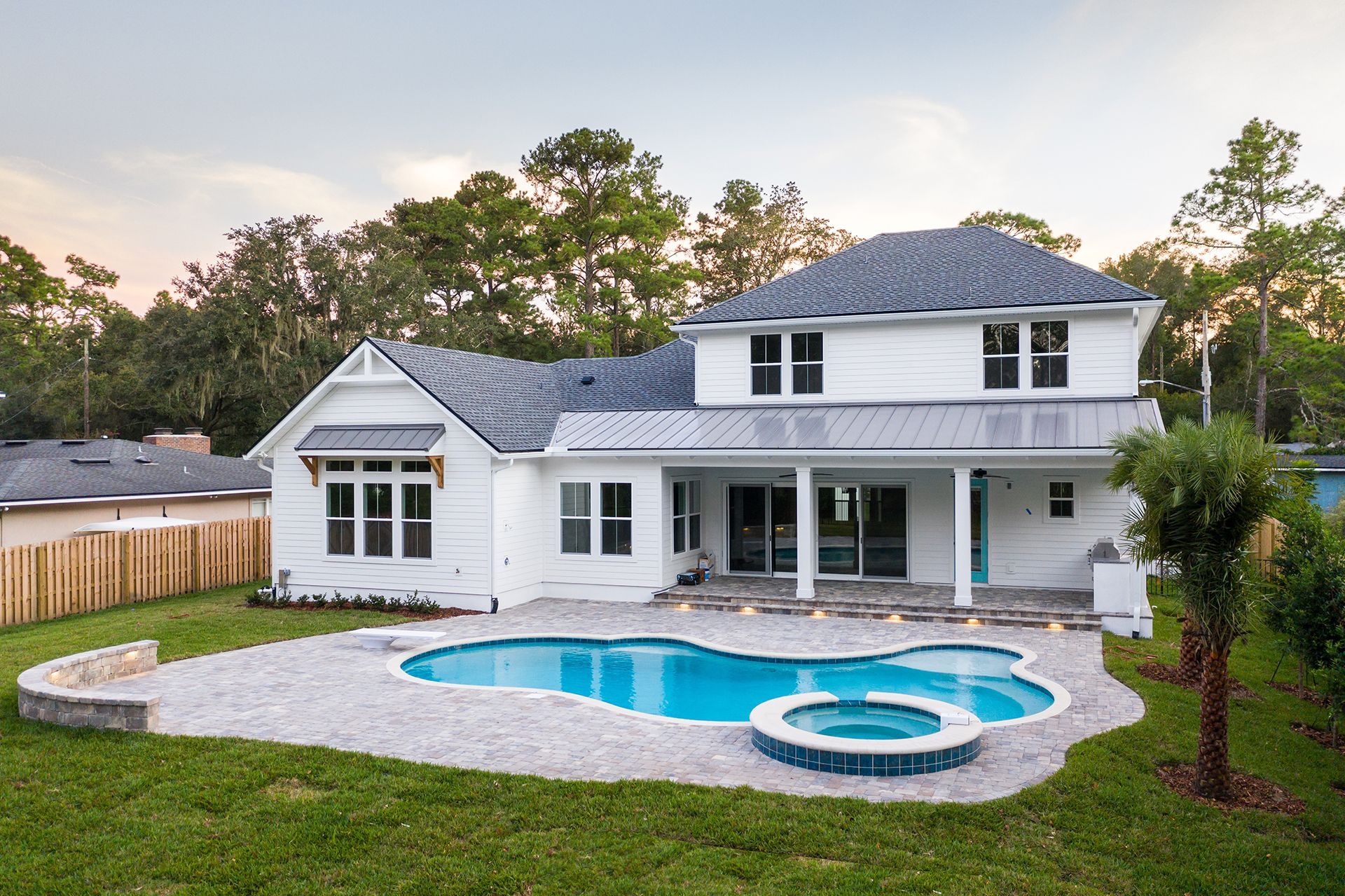 A large white house with a large swimming pool in the backyard.