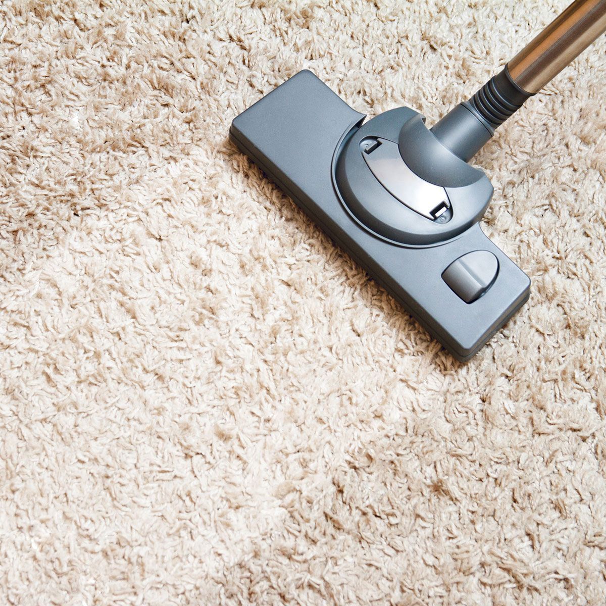 A vacuum cleaner is being used to clean a carpet