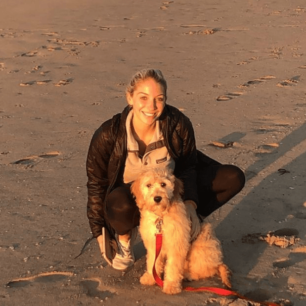 happy woman with mini golden retriever at the beach