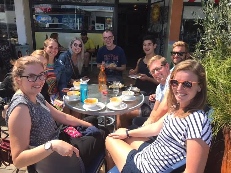 A group of people are sitting around a table eating food.