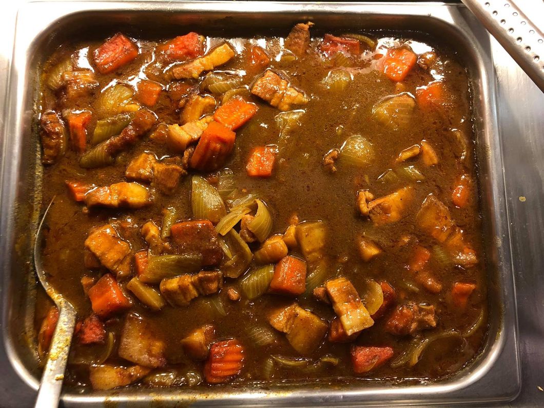 A tray of stew with carrots and green beans