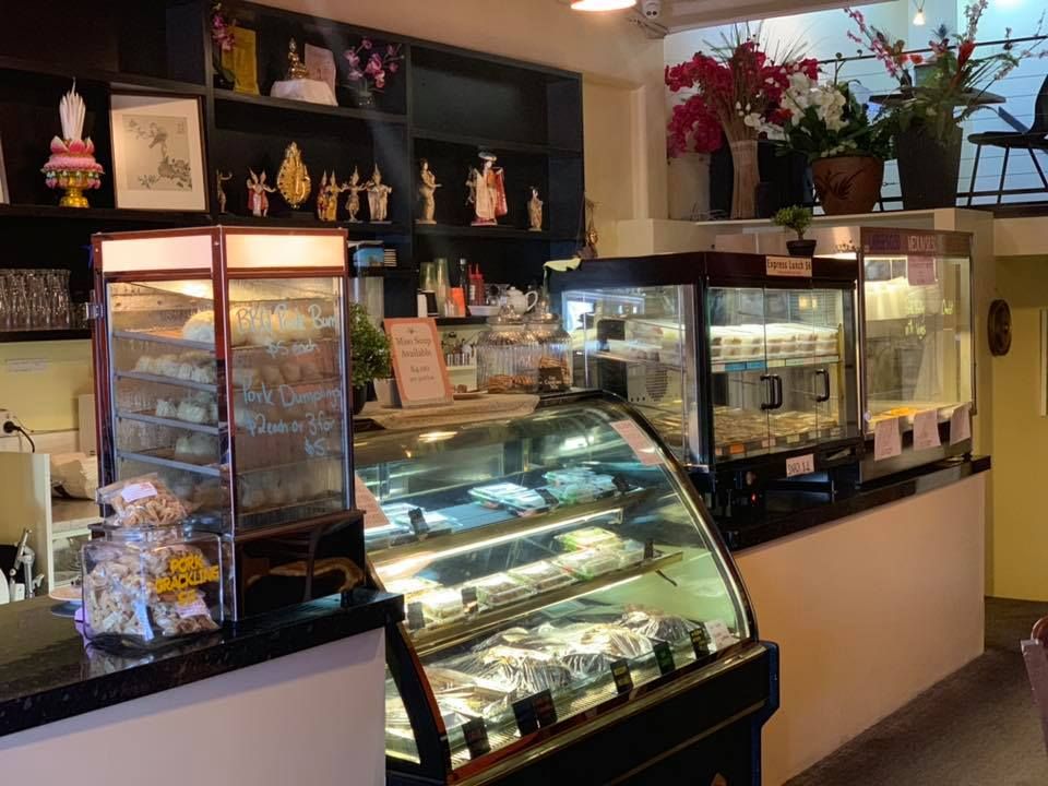 A bakery with a glass display case filled with lots of food.