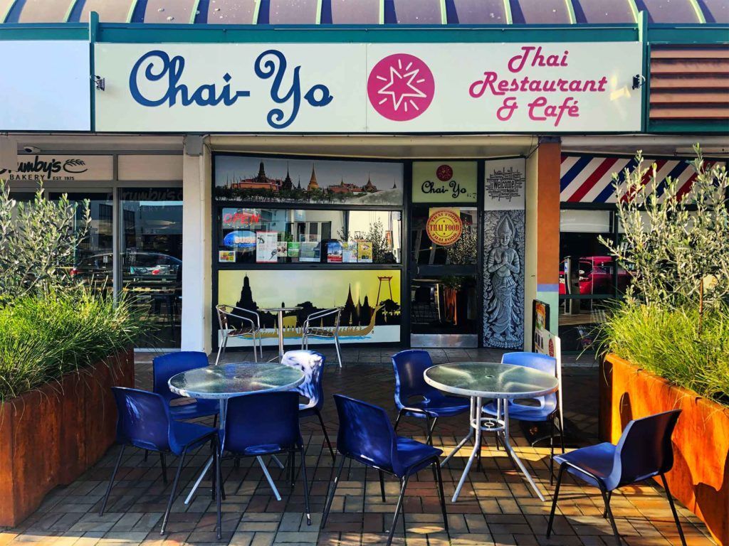 A thai restaurant and cafe with tables and chairs outside