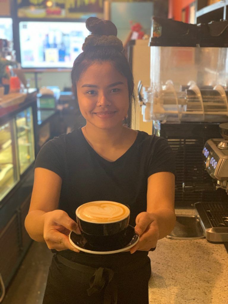 A woman is holding a cup of coffee in her hands.