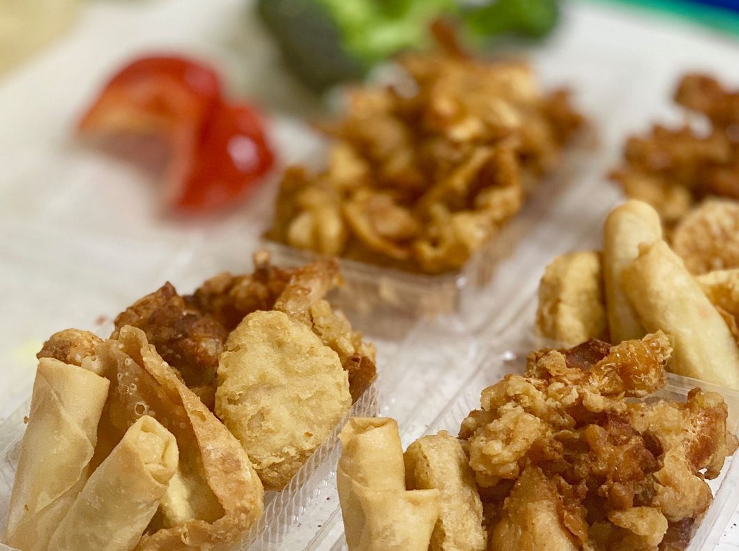 A close up of fried food in plastic containers on a table.