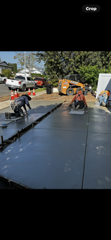 A group of men are working on a concrete driveway.