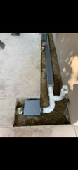 A drain pipe is being installed in a hole in the ground.