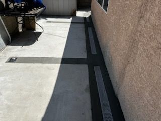 A concrete walkway leading to a house with a table in the background.