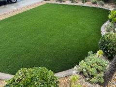 A lush green lawn with a car parked in the background.