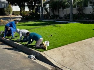 A group of people are working on a lush green lawn.