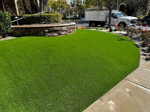 A white truck is parked in front of a lush green lawn.