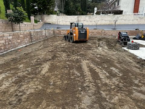 A bulldozer is driving through a dirt field.