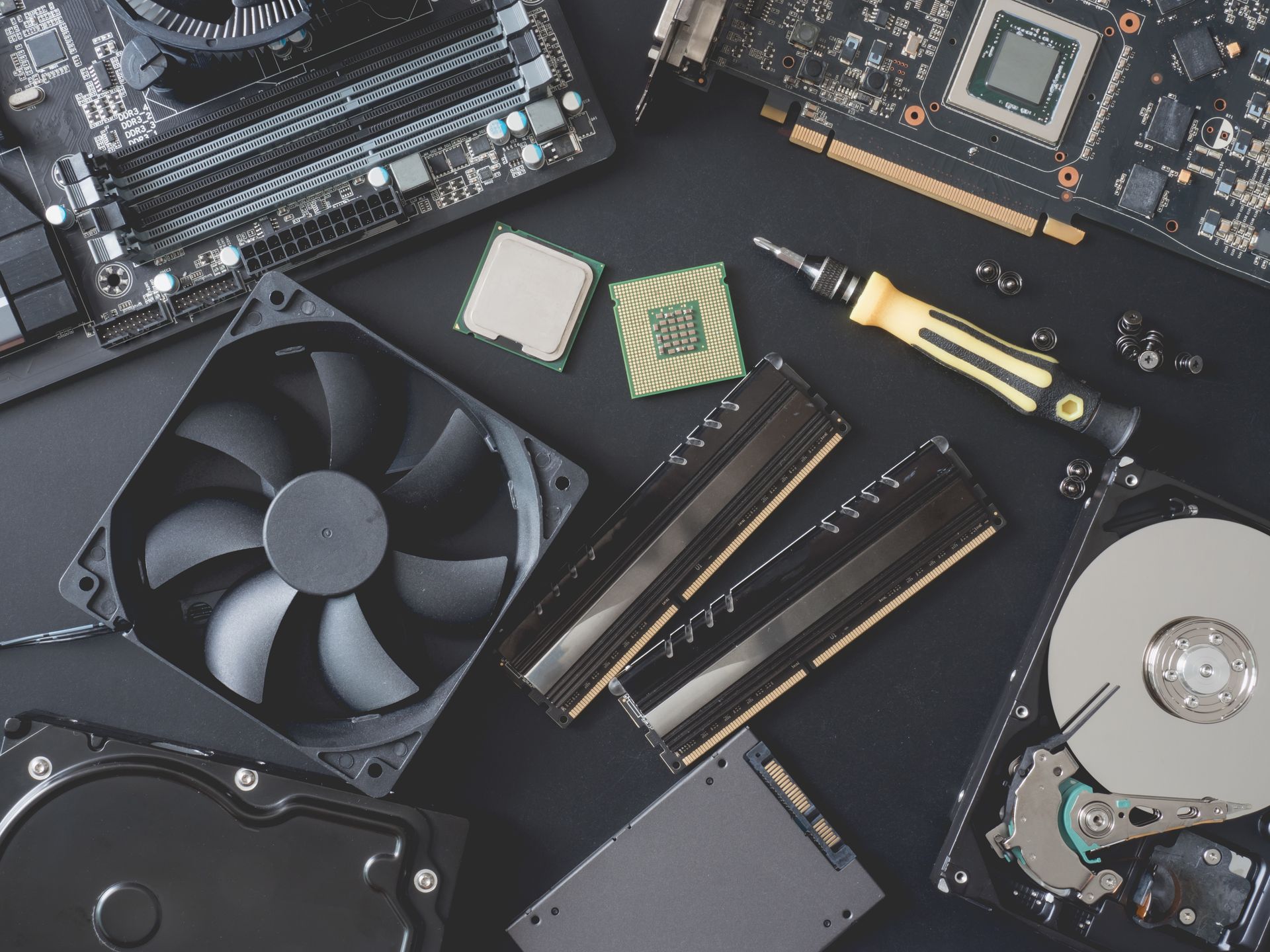 Computer hardware components: motherboard, CPU, RAM, fan, hard drives, and GPU.