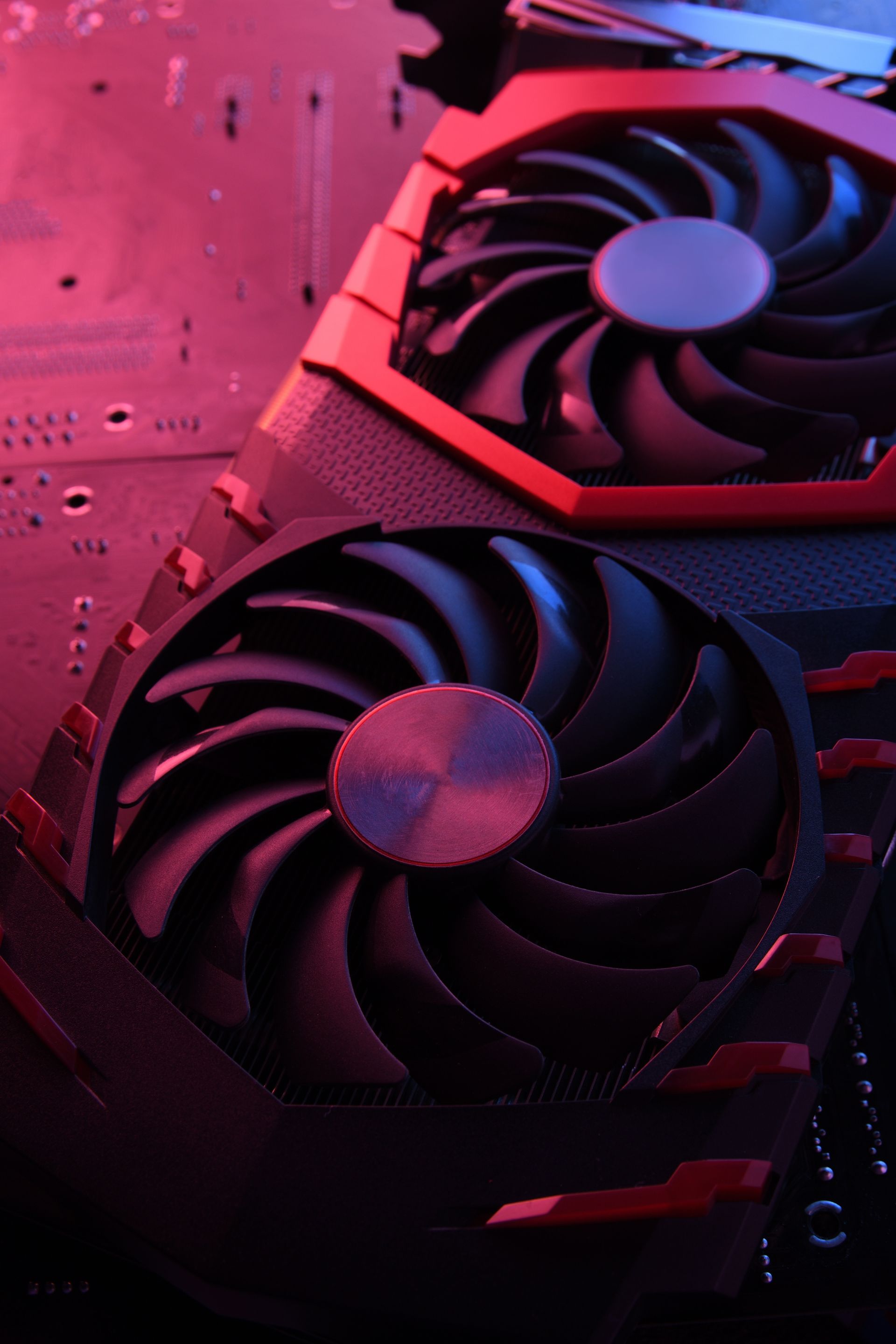 Close-up of a graphics card with two large fans, lit with red and blue light.